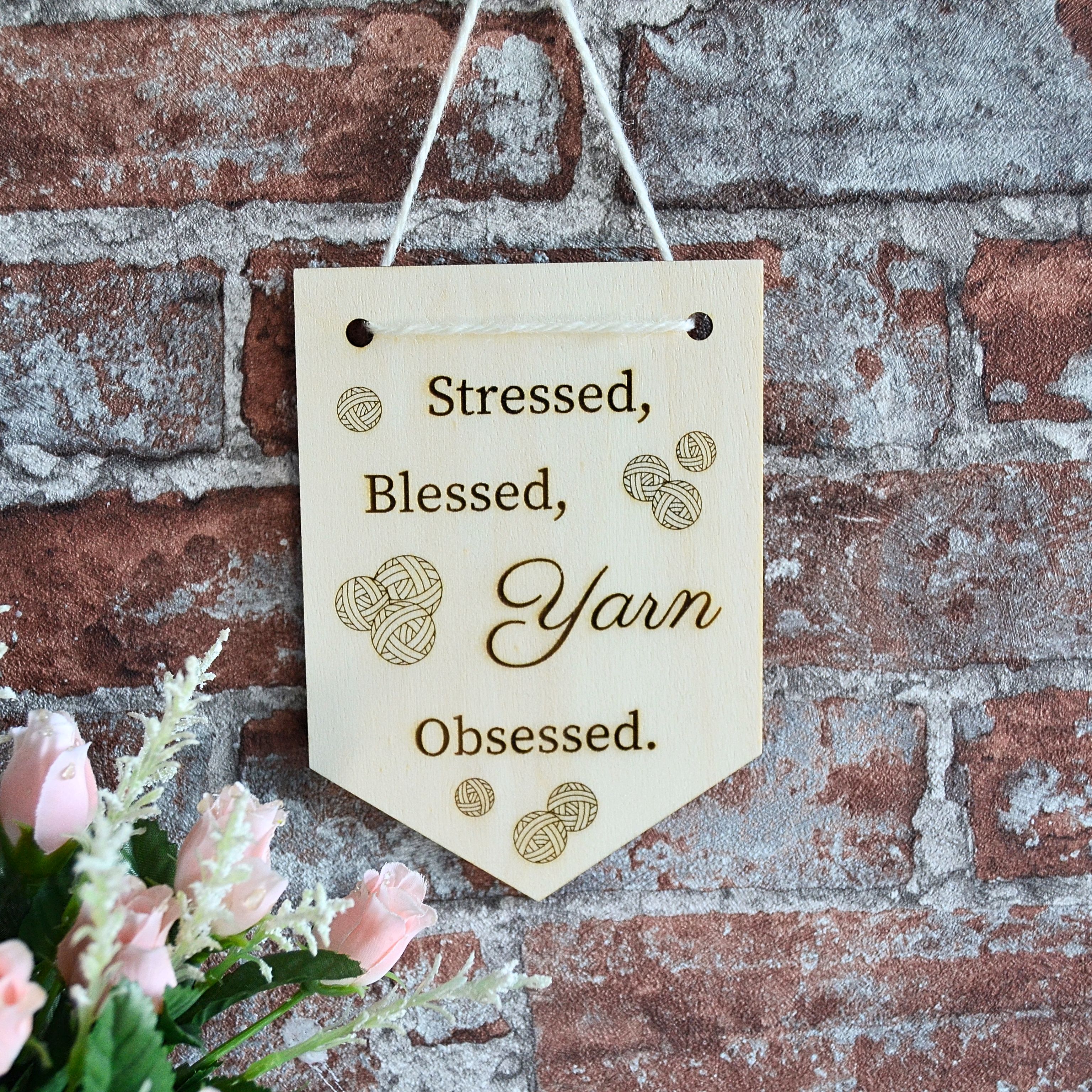 Holz Wimpel "Stressed, blessed, yarn obsessed." an Wand