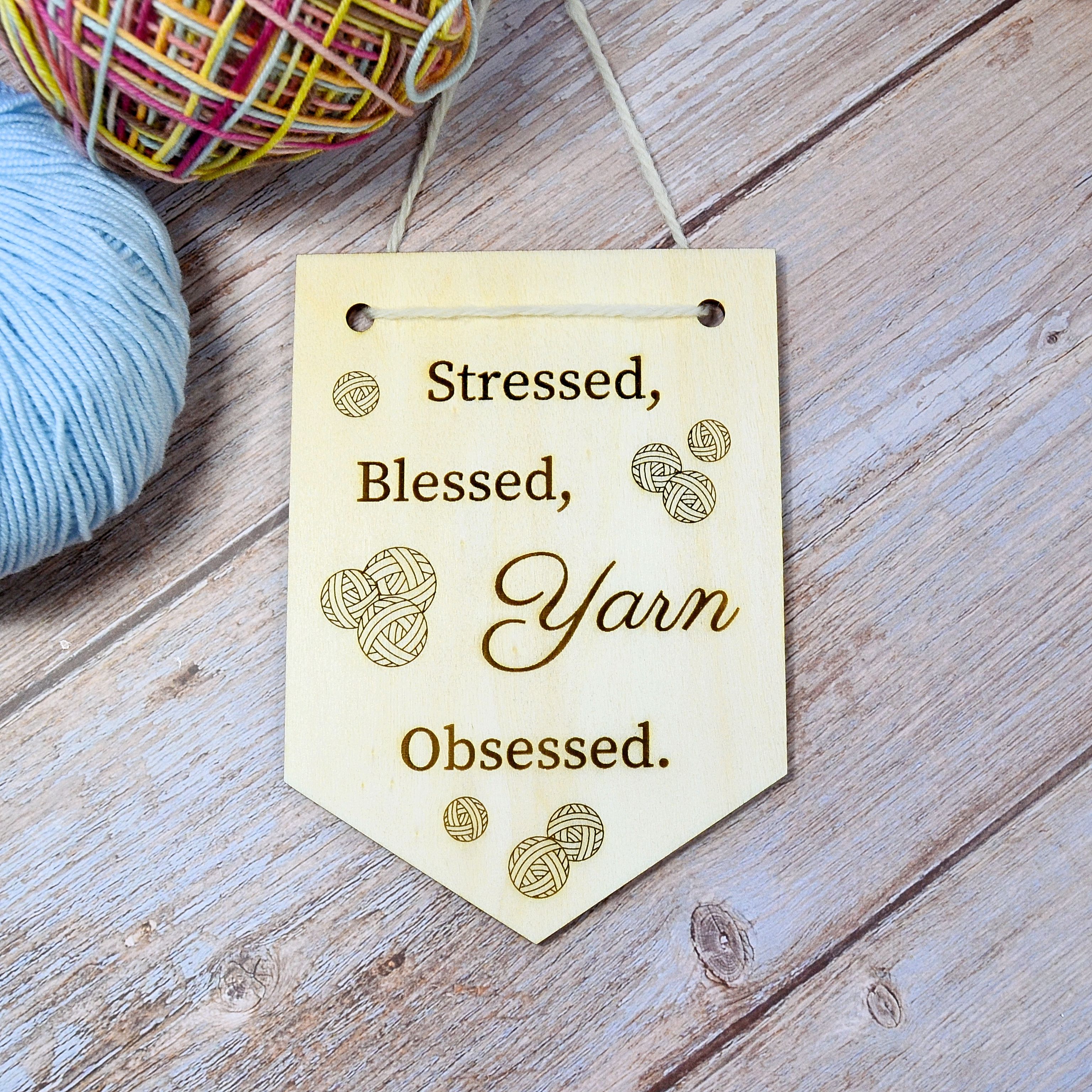 Wooden pennant "Stressed, blessed, yarn obsessed." made from FSC-certified poplar wood. 
